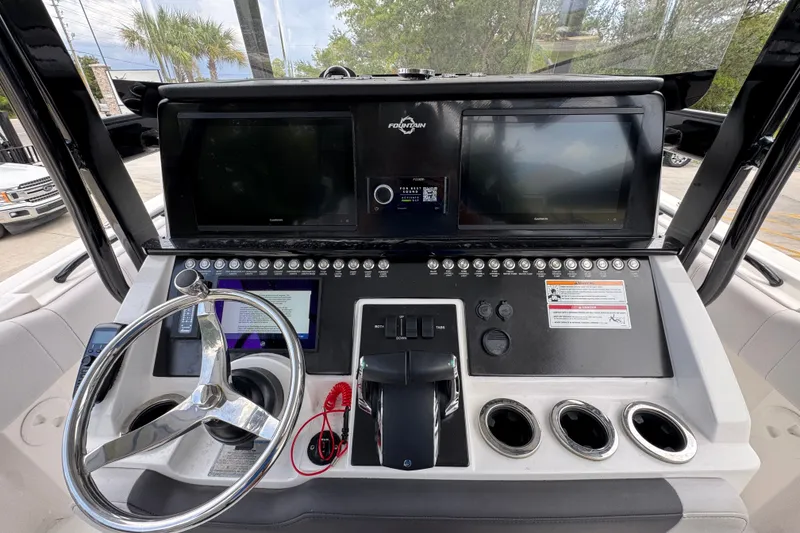 Slide: The Image of 2024 Fountain 34 Tournament Edition boat dashboard with dual screens and control panel. - 37