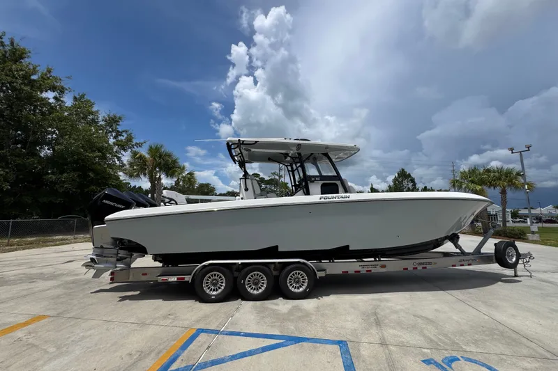Slide: The Image of 2024 Fountain 34 Tournament Edition boat on trailer under cloudy sky. - 12