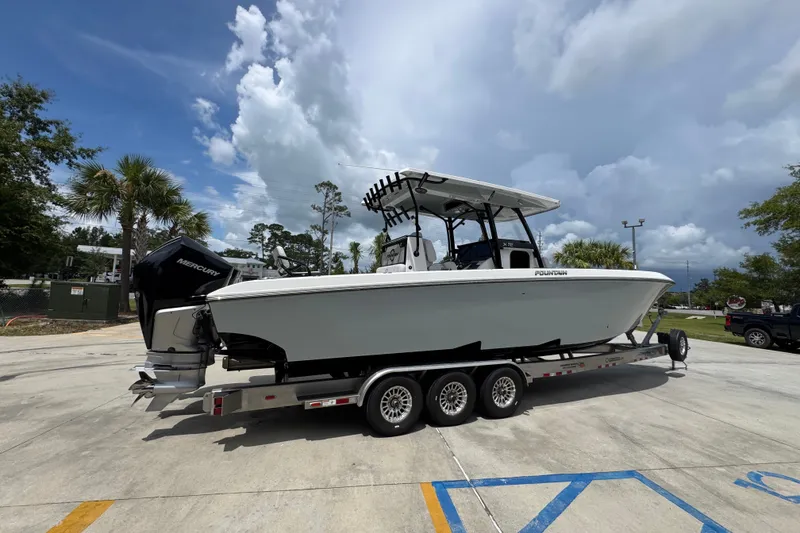 Slide: The Image of 2024 Fountain 34 Tournament Edition boat on trailer, parked outdoors under cloudy sky. - 13