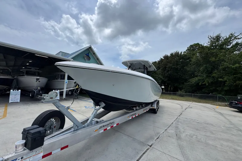 Slide: The Image of 2024 Fountain 34 Tournament Edition boat on trailer, parked outdoors under cloudy sky. - 5