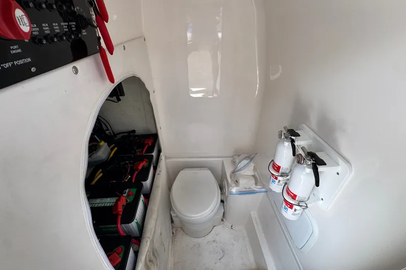 Slide: The Image of 2024 Fountain 34 Tournament Edition boat interior with toilet, fire extinguishers, and battery compartment. - 30