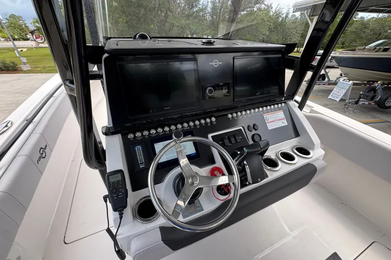 Slide: The Image of 2024 Fountain 34 Tournament Edition boat dashboard with steering wheel and control panel. - 36