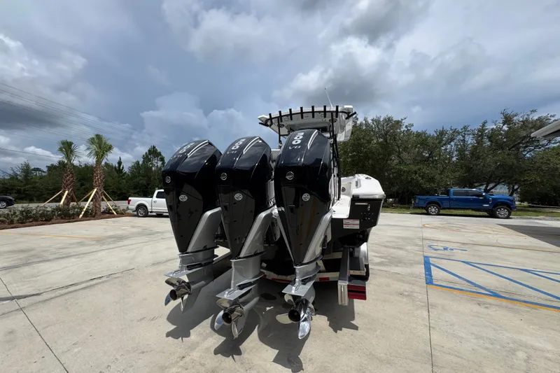 Slide: The Image of 2024 Fountain 34 Tournament Edition boat with triple outboard engines in a parking lot. - 16