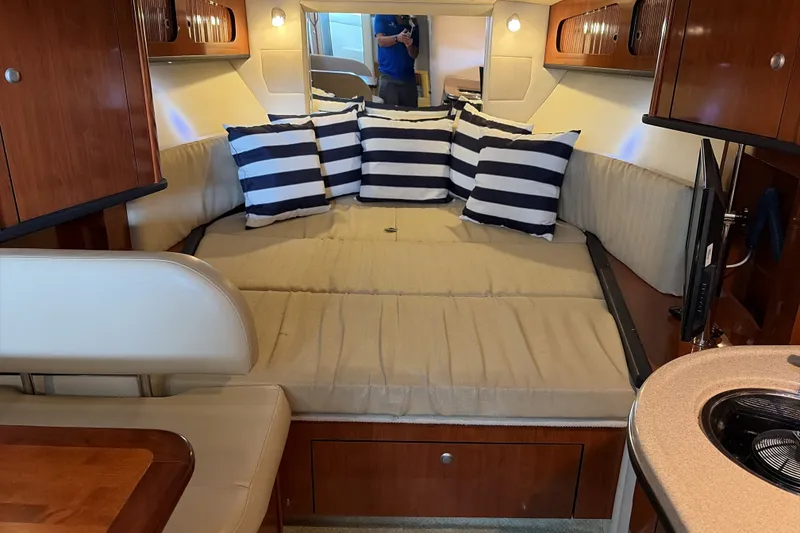 Slide: The Image of Interior of 2007 Sea Ray 290 Sundancer with striped pillows and cozy seating area. - 41