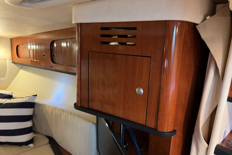 Slide: The Image of Interior cabin of 2007 Sea Ray 290 Sundancer with wood cabinetry and striped cushion. - 26