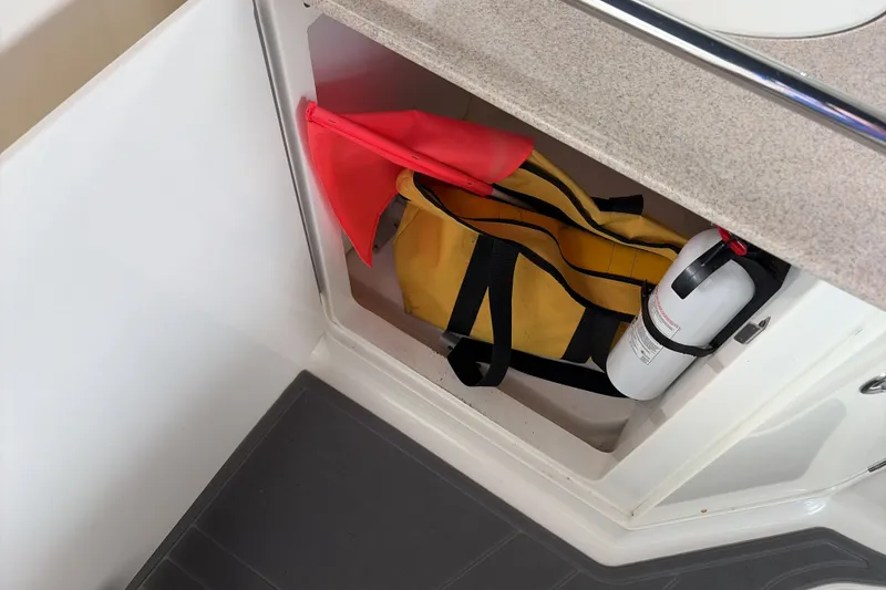 Slide: The Image of Storage compartment on 2007 Sea Ray 290 Sundancer with safety equipment and fire extinguisher. - 14