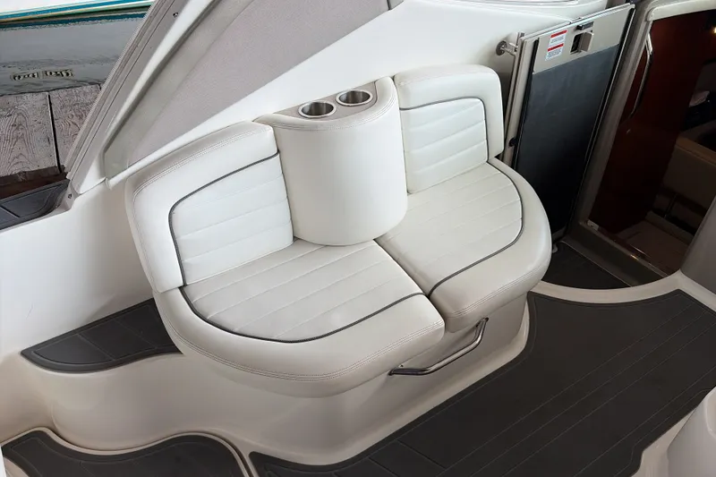 Slide: The Image of 2007 Sea Ray 290 Sundancer boat interior with white cushioned seating and cup holders. - 17