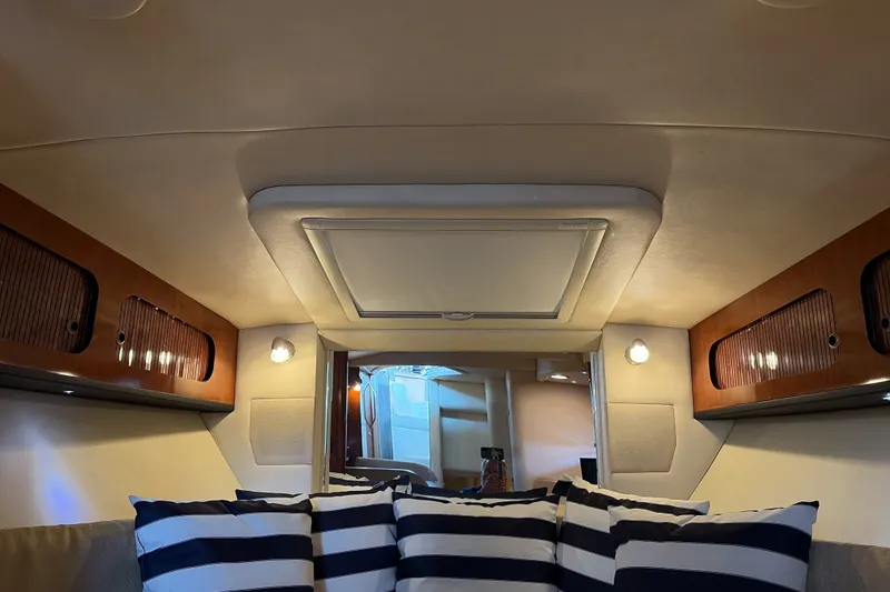 Slide: The Image of Interior of 2007 Sea Ray 290 Sundancer with striped cushions and wooden cabinets. - 40
