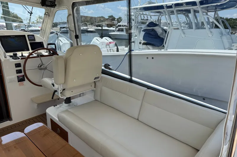 Slide: The Image of Interior of 2018 MJM 35z boat with helm, seating, and marina view. - 17