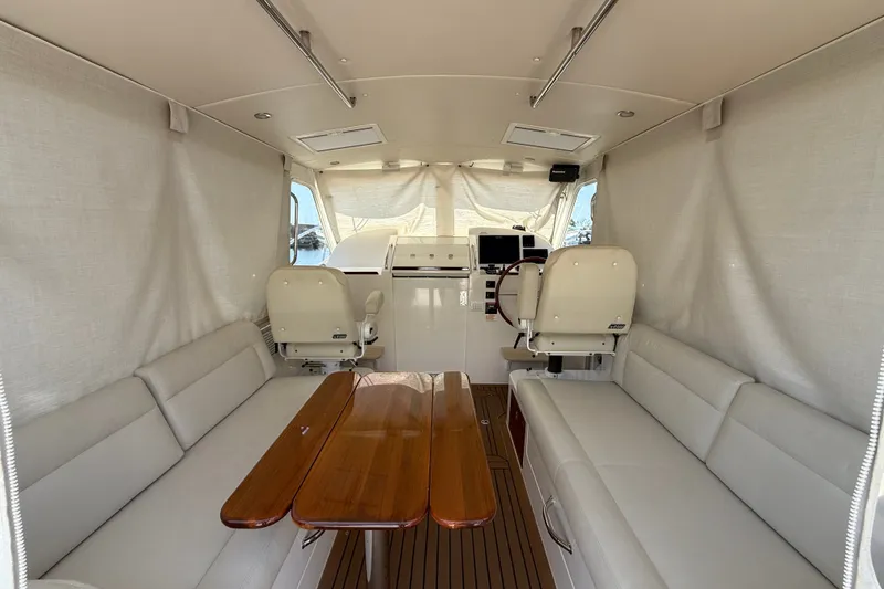 Slide: The Image of Interior of 2018 MJM 35z boat with white seating and wooden table. - 25