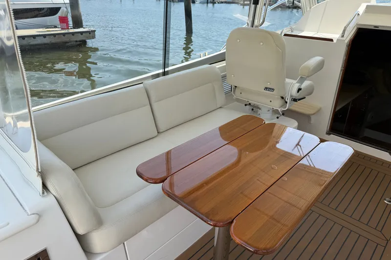 Slide: The Image of Luxury seating area on a 2018 MJM 35z yacht with wooden table and waterfront view. - 15