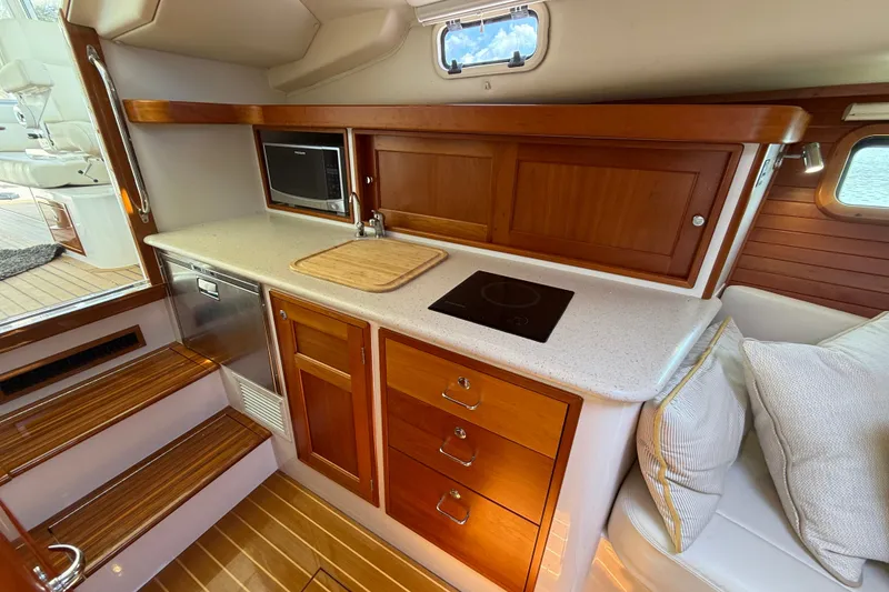 Slide: The Image of Luxurious 2018 MJM 35z yacht interior with modern kitchenette and wooden cabinetry. - 31