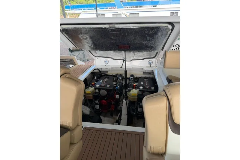 Slide: The Image of Engine compartment of 2015 Cruisers Sport Series 328 boat, featuring dual engines and tan seating. - 32