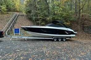 Slide: The Image of 2015 Cruisers Sport Series 328 boat on trailer in wooded area. - 7