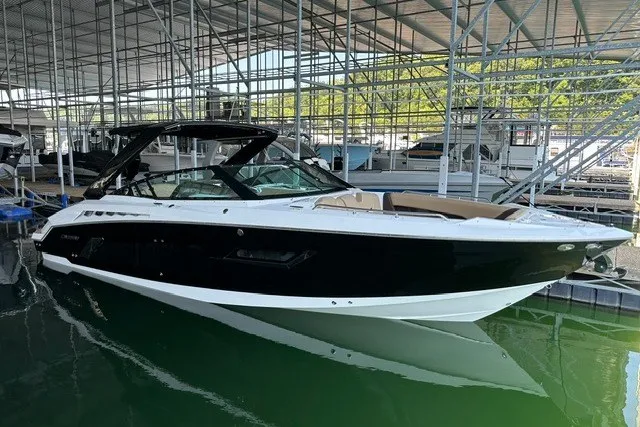 Slide: The Image of 2015 Cruisers Sport Series 328 boat docked in marina, sleek black and white design. - 6