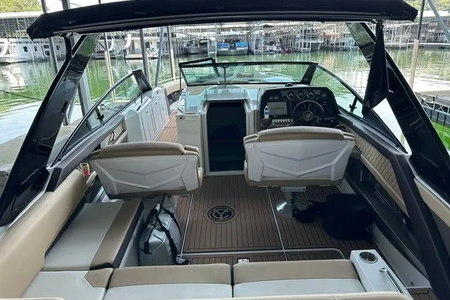 Slide: The Image of 2015 Cruisers Sport Series 328 boat interior with seating and dashboard, docked at marina. - 35