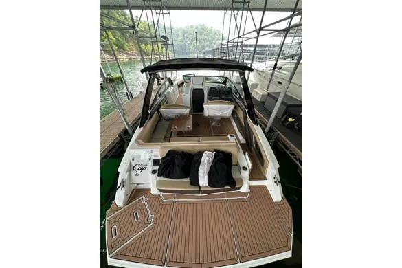 Slide: The Image of 2015 Cruisers Sport Series 328 boat docked, featuring spacious deck and seating area. - 14
