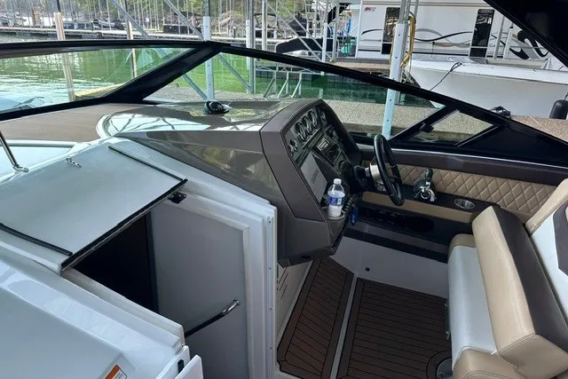 Slide: The Image of 2015 Cruisers Sport Series 328 boat interior with helm, steering wheel, and seating. - 8
