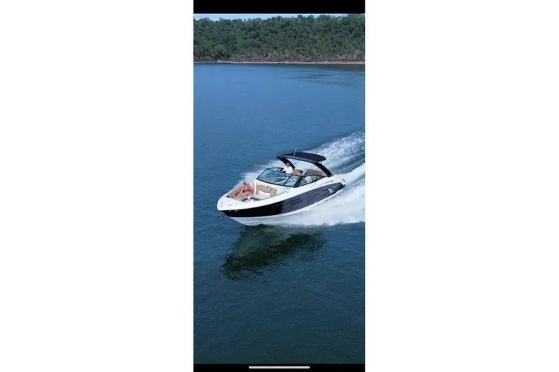 Slide: The Image of 2015 Cruisers Sport Series 328 boat cruising on a serene lake. - 12