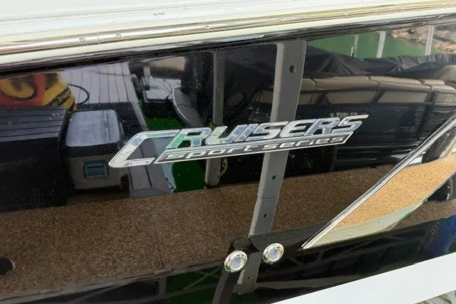 Slide: The Image of 2015 Cruisers Sport Series 328 boat logo on sleek black surface. - 22