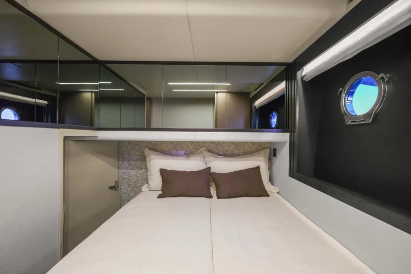 Slide: The Image of Luxurious cabin interior of 2026 Absolute 52 Fly yacht with modern bedding and porthole windows. - 52