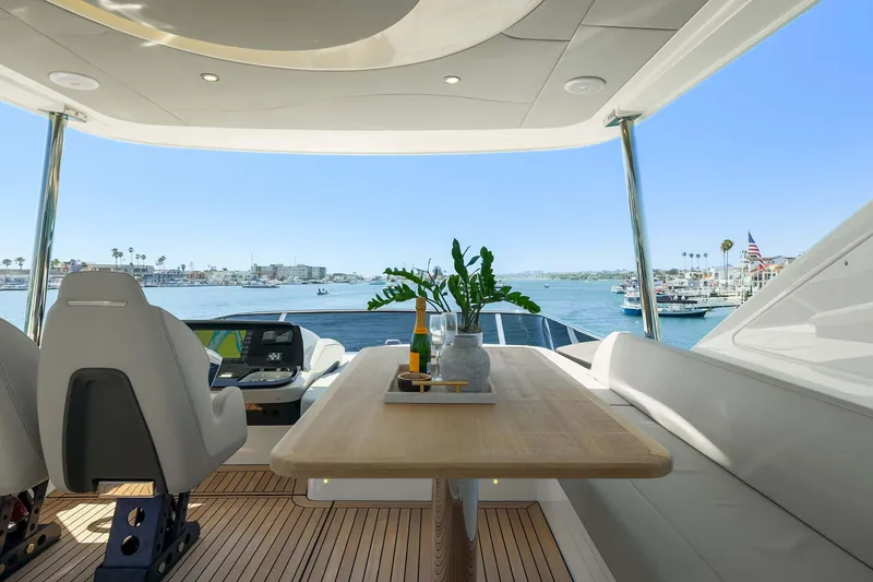 Slide: The Image of Luxurious Absolute 52 Fly yacht interior with ocean view, featuring elegant seating and a wooden table. - 17