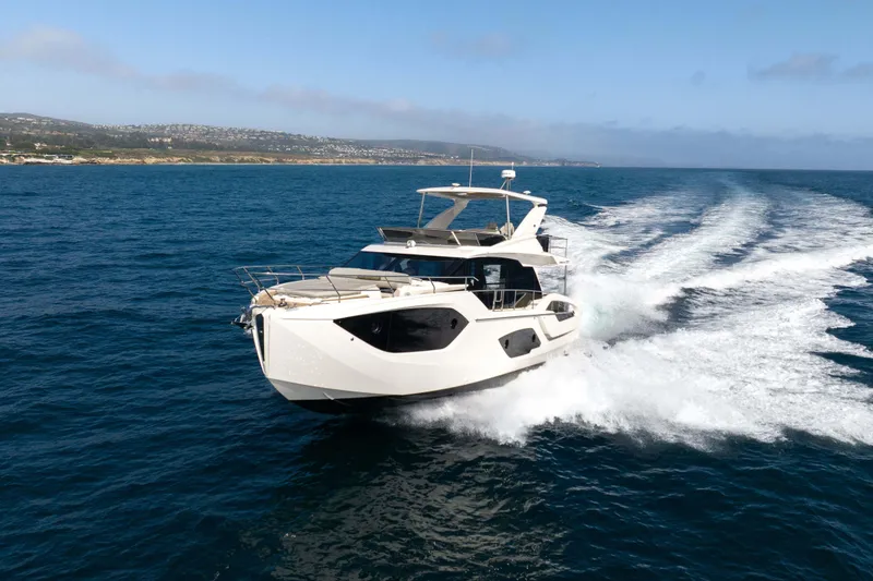 Slide: The Image of 2026 Absolute 52 Fly yacht cruising on open sea under clear blue sky. - 10