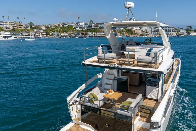 Slide: The Image of Luxury Absolute 52 Fly yacht cruising near scenic coastal town, 2026 model. - 4