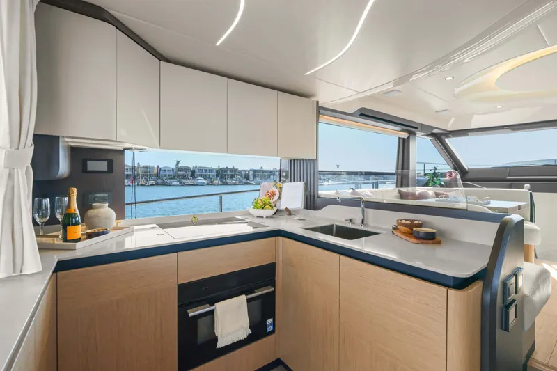 Slide: The Image of Luxurious interior of 2026 Absolute 52 Fly yacht with modern kitchen and scenic marina view. - 33