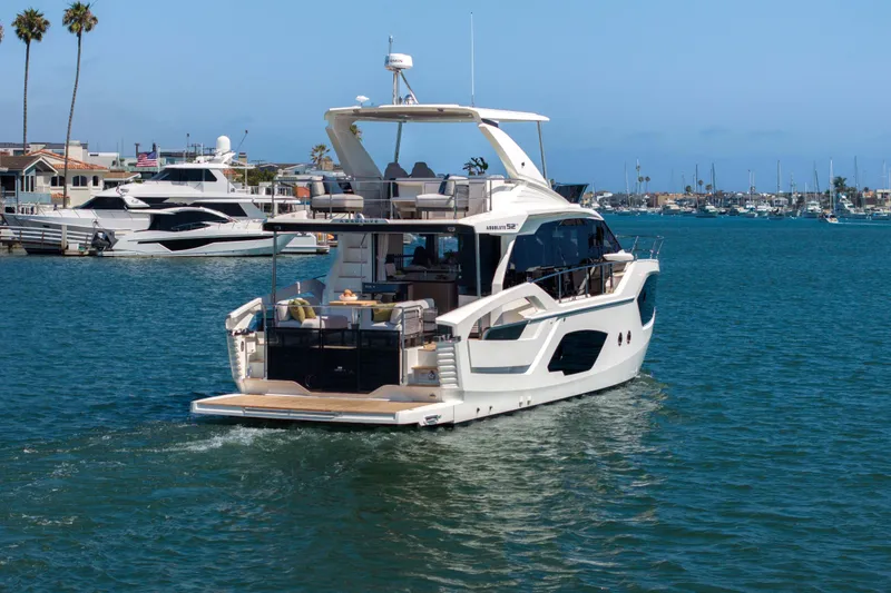 Slide: The Image of Luxury Absolute 52 Fly yacht cruising in a scenic harbor, 2026 model. - 2