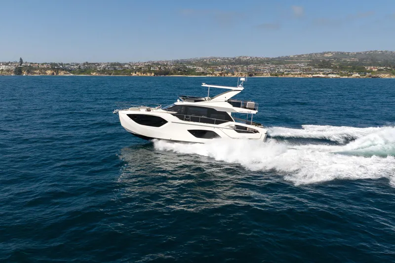 Slide: The Image of 2026 Absolute 52 Fly yacht cruising on open sea with coastal backdrop. - 12