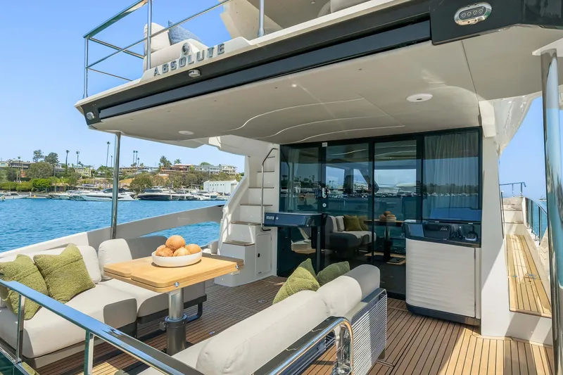 Slide: The Image of Luxurious 2026 Absolute 52 Fly yacht with elegant outdoor seating and scenic waterfront view. - 19