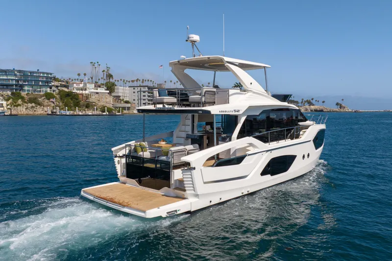 Slide: The Image of Luxury Absolute 52 Fly yacht cruising near coastal buildings, 2026 model. - 6