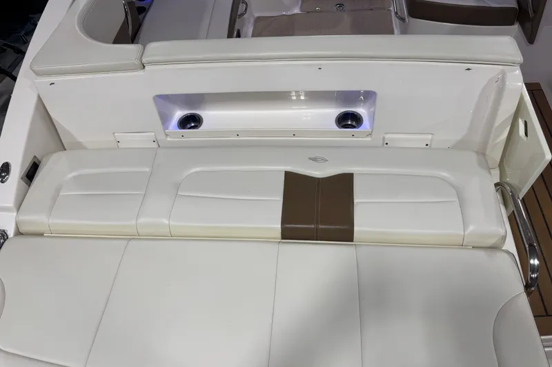 Slide: The Image of 2016 Chaparral 307 SSX boat interior with white and brown cushioned seating. - 8