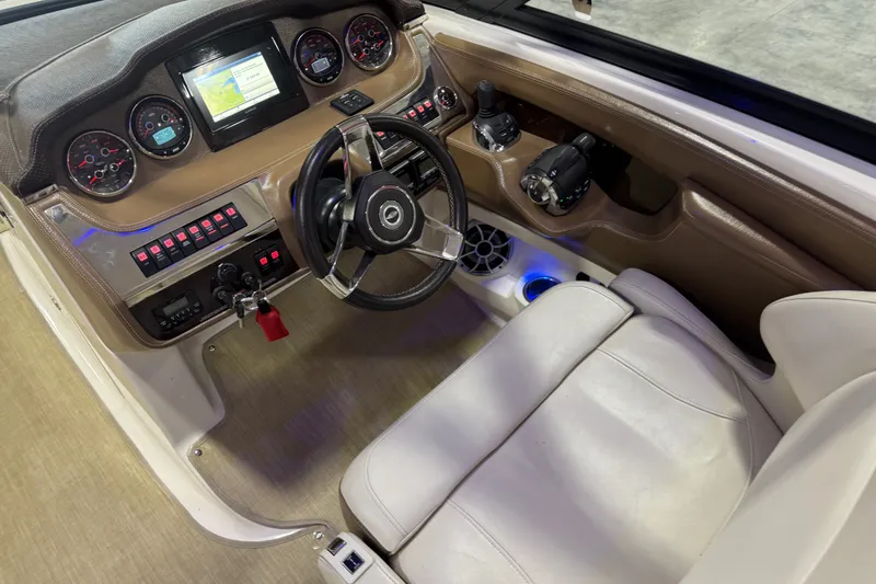 Slide: The Image of 2016 Chaparral 307 SSX boat cockpit with steering wheel, gauges, and navigation screen. - 13