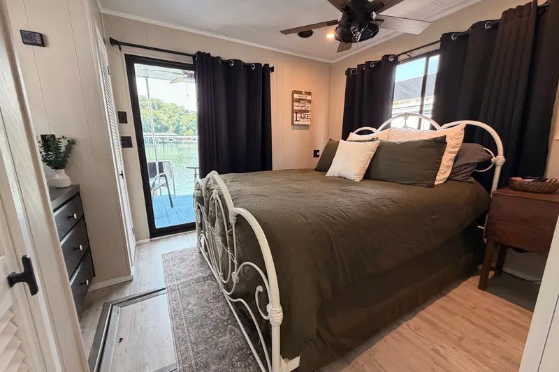 Slide: The Image of Cozy bedroom in a 1991 Leisure Time 14x63 houseboat with lake view and elegant decor. - 36