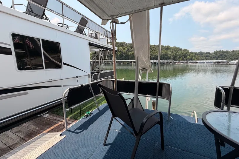 Slide: The Image of Houseboat deck view with chairs, table, and serene lake backdrop, Leisure Time 14x63, 1991 model. - 43