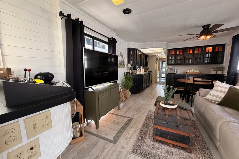 Slide: The Image of Cozy 1991 Leisure Time 14x63 interior with modern decor, featuring a TV, sofa, and dining area. - 15