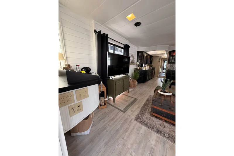 Slide: The Image of Cozy 1991 Leisure Time 14x63 mobile home interior with modern decor and wood flooring. - 16