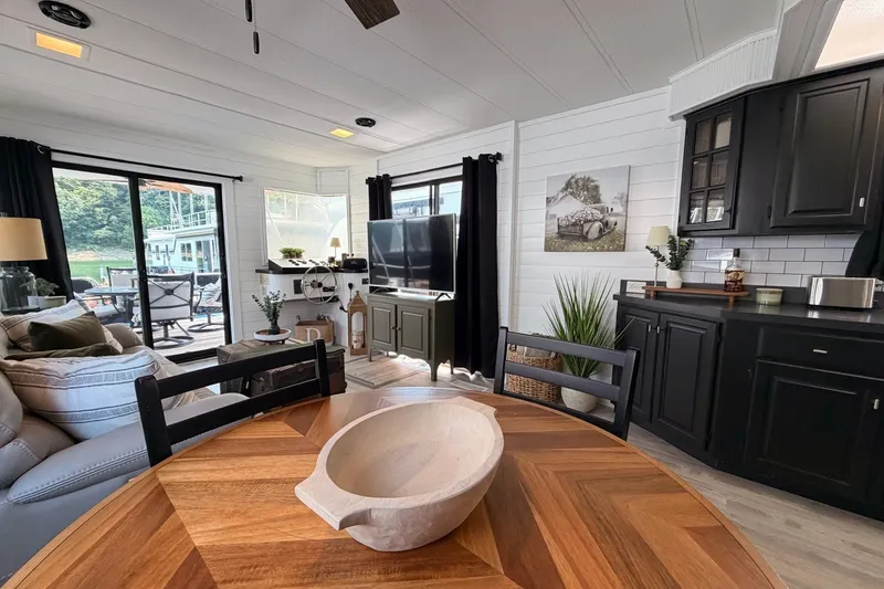 Slide: The Image of Cozy 1991 Leisure Time 14x63 interior with modern decor, wooden table, and large windows. - 22