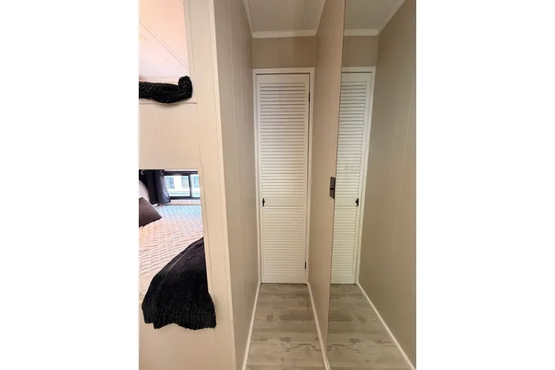 Slide: The Image of Narrow hallway with louvered closet doors in a 1991 Leisure Time 14x63 model. - 28
