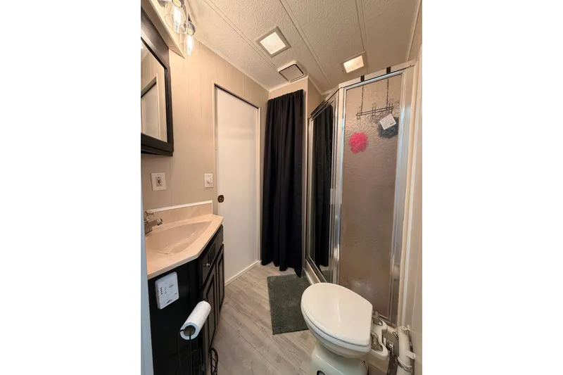 Slide: The Image of Compact 1991 Leisure Time bathroom with shower, sink, and toilet in a mobile home. - 31