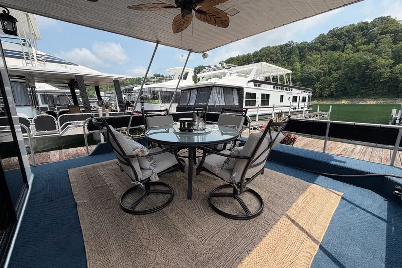 Slide: The Image of Outdoor seating on a 1991 Leisure Time 14x63 houseboat, docked by a scenic lake. - 11