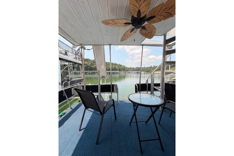 Slide: The Image of Covered deck of 1991 Leisure Time houseboat with chairs, table, and scenic lake view. - 39