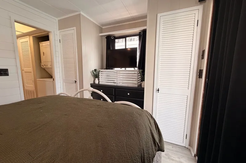 Slide: The Image of Cozy bedroom in 1991 Leisure Time model, featuring TV, dresser, and laundry area. - 38