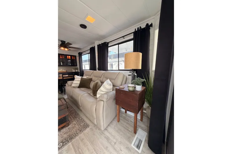 Slide: The Image of Cozy living room in 1991 Leisure Time model, featuring beige sofa, wooden side table, and decor. - 17