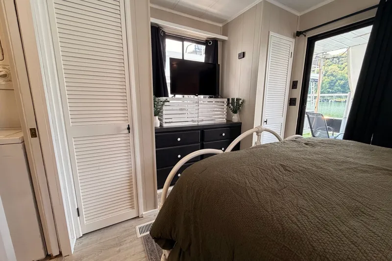 Slide: The Image of Cozy bedroom in 1991 Leisure Time model, featuring a TV, dresser, and outdoor view. - 37