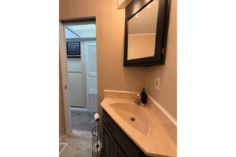 Slide: The Image of Compact bathroom in 1991 Leisure Time model, featuring a corner sink and mirror. - 32
