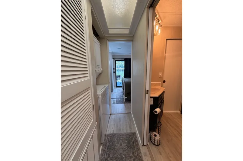 Slide: The Image of Hallway in a 1991 Leisure Time 14x63 mobile home, featuring a bathroom and laundry area. - 30