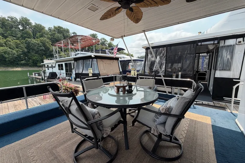 Slide: The Image of Outdoor seating on a 1991 Leisure Time 14x63 houseboat, docked by a scenic lake. - 8